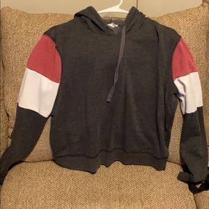 Grey sweater with pink and white stripes on sleeve